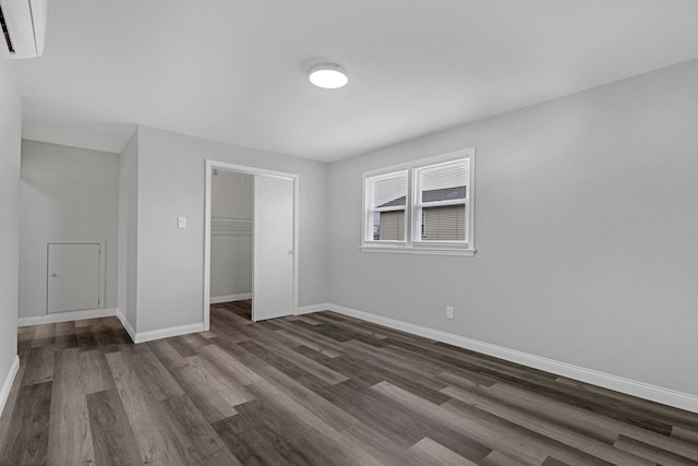 6037 S Mason Ave, Chicago, IL 60638 - unfurnished bedroom with a wall unit AC, dark wood-style floors, baseboards, and a closet