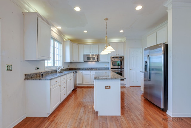 15 Open Pkwy N, Hawthorn Woods, IL 60047 - kitchen featuring appliances with stainless steel finishes, a kitchen island, crown molding, light wood-style flooring, and white cabinets