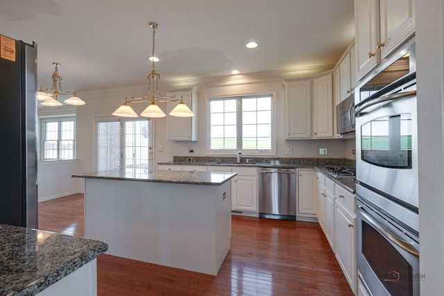 15 Open Pkwy N, Hawthorn Woods, IL 60047 - kitchen featuring appliances with stainless steel finishes, healthy amount of natural light, a kitchen island, dark wood-style floors, and crown molding