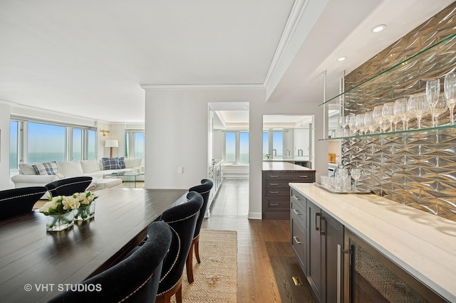 132 E Delaware Pl Unit 5106, Chicago, IL 60611 - dining space with a bar, ornamental molding, dark wood-style floors, and recessed lighting