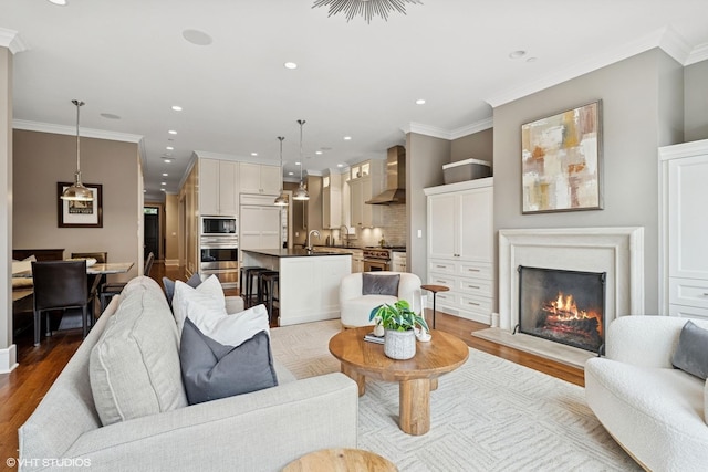 1230 W Cornelia Ave, Chicago, IL 60657 - living room with recessed lighting, a warm lit fireplace, light wood-style flooring, and crown molding