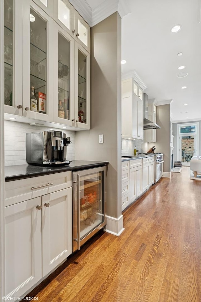 1230 W Cornelia Ave, Chicago, IL 60657 - indoor bar featuring beverage cooler, crown molding, wall chimney range hood, backsplash, and light wood finished floors