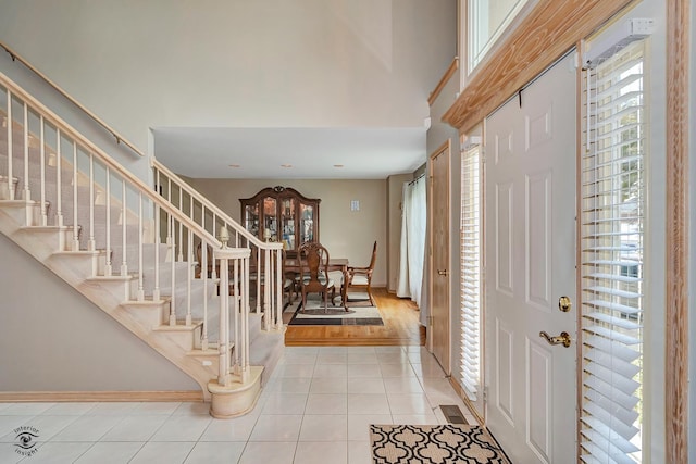 16924 Yearling Crossing Dr, Orland Park, IL 60467 - foyer featuring light tile patterned floors, stairs, a towering ceiling, and baseboards