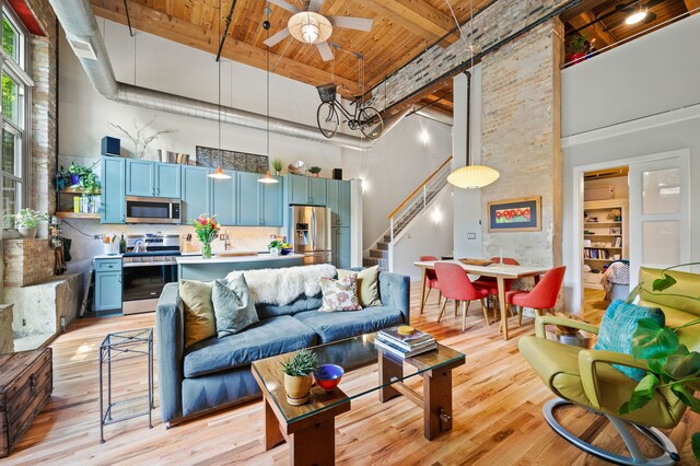 2111 W Churchill St Unit 112, Chicago, IL 60647 - living room featuring a towering ceiling, a wooden ceiling with exposed beams, stairs, light wood-type flooring, and a ceiling fan