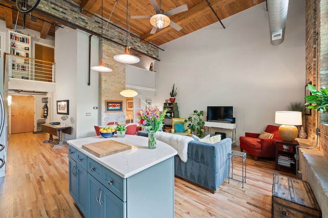 2111 W Churchill St Unit 112, Chicago, IL 60647 - kitchen featuring a towering ceiling, blue cabinets, a ceiling fan, a wooden ceiling with exposed beams, and light wood-type flooring