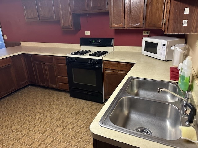 27125 N Williams Park Rd N, Wauconda, IL 60084 - kitchen with black range with gas cooktop, white microwave, light countertops, and dark brown cabinets