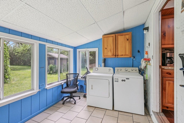 20214 Harmony Rd, Marengo, IL 60152 - laundry area with cabinet space, washer and clothes dryer, light tile patterned floors, healthy amount of natural light, and wooden walls