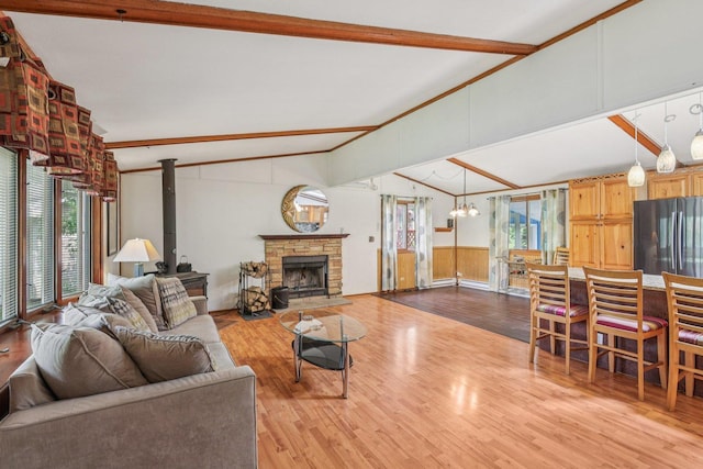20214 Harmony Rd, Marengo, IL 60152 - living room featuring healthy amount of natural light, wood finished floors, a chandelier, wainscoting, and a stone fireplace
