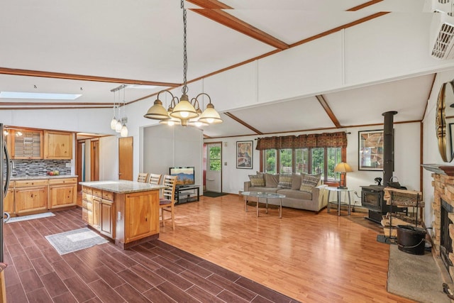 20214 Harmony Rd, Marengo, IL 60152 - kitchen featuring open floor plan, high vaulted ceiling, decorative backsplash, light stone counters, and a wood stove