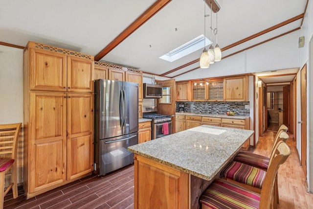 20214 Harmony Rd, Marengo, IL 60152 - kitchen with appliances with stainless steel finishes, a skylight, lofted ceiling, dark wood-style floors, and light stone counters