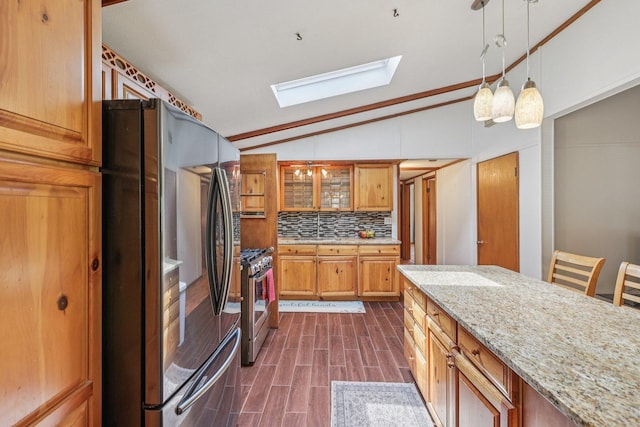 20214 Harmony Rd, Marengo, IL 60152 - kitchen featuring stainless steel appliances, a skylight, vaulted ceiling, tasteful backsplash, and light stone countertops