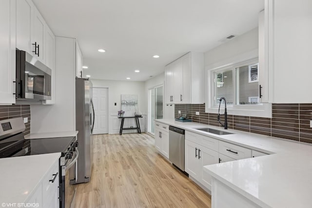 20534 Arcadian Dr, Olympia Fields, IL 60461 - kitchen featuring stainless steel appliances, a sink, white cabinets, light wood-style floors, and recessed lighting