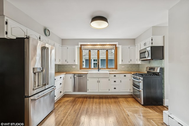 408 W Campbell St, Arlington Heights, IL 60005 - kitchen with stainless steel appliances, white cabinets, tasteful backsplash, and a baseboard radiator