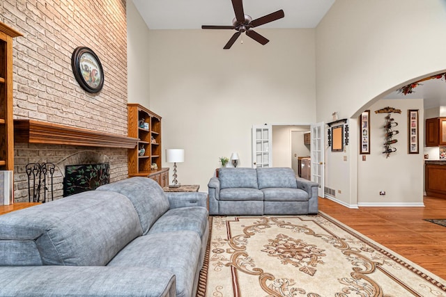 1440 Monarch Cir, Naperville, IL 60564 - living area featuring a towering ceiling, a ceiling fan, arched walkways, wood finished floors, and baseboards