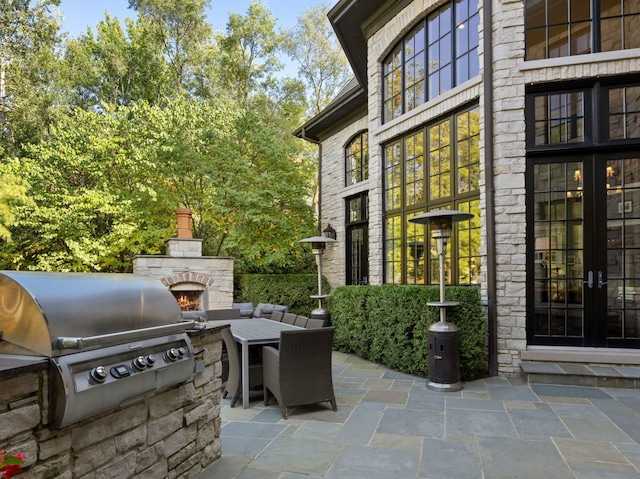 15W120 60th St, Burr Ridge, IL 60527 - view of patio / terrace with an outdoor stone fireplace and area for grilling