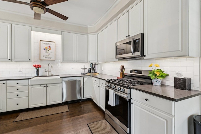1714 Waverly Cir, Saint Charles, IL 60174 - kitchen with appliances with stainless steel finishes, dark countertops, white cabinetry, decorative backsplash, and ornamental molding