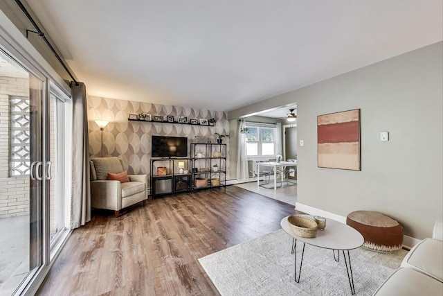 6468 N NW Hwy Unit A1, Chicago, IL 60631 - living area with an accent wall, wood finished floors, wallpapered walls, and a ceiling fan