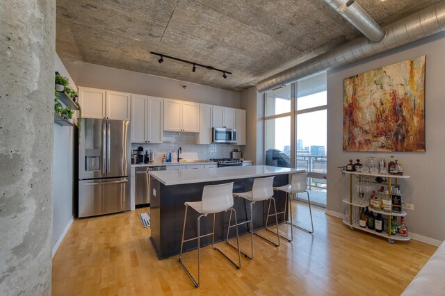 700 N Larrabee St Unit 1315, Chicago, IL 60654 - kitchen featuring stainless steel appliances, light wood-style floors, white cabinets, and light countertops