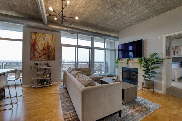 700 N Larrabee St Unit 1315, Chicago, IL 60654 - living room featuring wood finished floors, a fireplace, a chandelier, baseboards, and a wall of windows