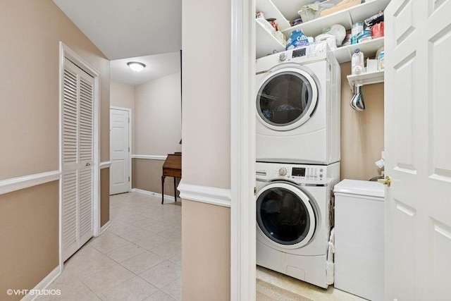 6807 N Milwaukee Ave Unit 708, Niles, IL 60714 - laundry area with stacked washer and clothes dryer, light tile patterned floors, and baseboards