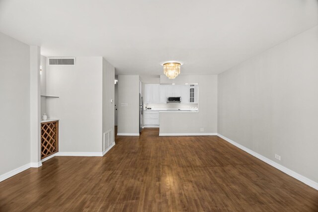6007 N Sheridan Rd Unit 37H, Chicago, IL 60660 - unfurnished living room with dark wood-style flooring, baseboards, and a chandelier