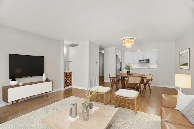 6007 N Sheridan Rd Unit 37H, Chicago, IL 60660 - living room featuring wood finished floors, baseboards, and a chandelier