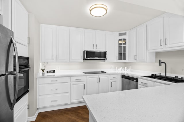 6007 N Sheridan Rd Unit 37H, Chicago, IL 60660 - kitchen featuring black appliances, a sink, glass insert cabinets, dark wood-type flooring, and white cabinetry