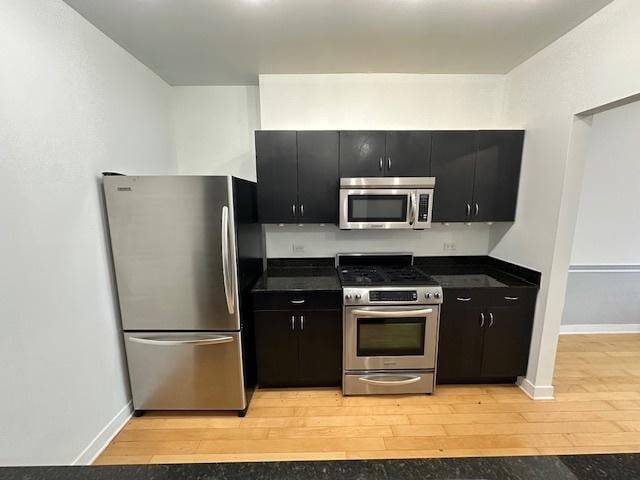 8 E Randolph St Unit 2702, Chicago, IL 60601 - kitchen with stainless steel appliances, dark cabinets, dark countertops, and light wood-type flooring