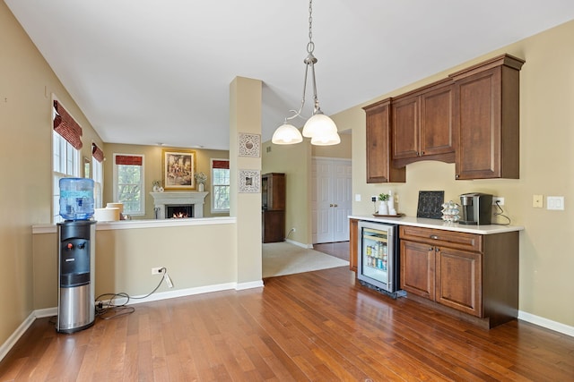 16266 W Mohawk Ct, Lockport, IL 60441 - kitchen with beverage cooler, dark wood-type flooring, light countertops, and decorative light fixtures