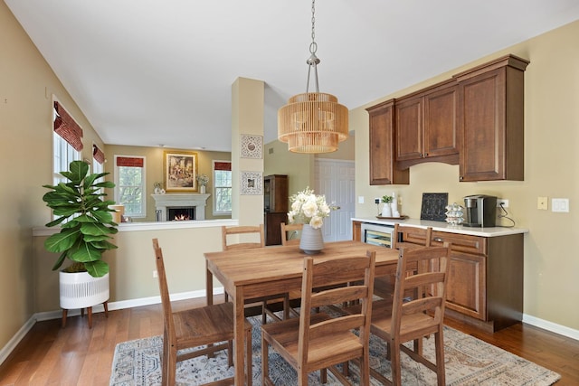 16266 W Mohawk Ct, Lockport, IL 60441 - dining area featuring wood finished floors, a chandelier, and a warm lit fireplace