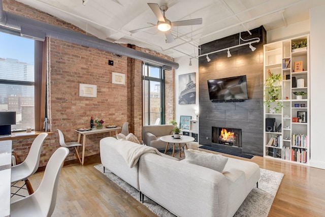 1322 S Wabash Ave Unit 407, Chicago, IL 60605 - living area featuring wood finished floors, ceiling fan, a fireplace, brick wall, and track lighting