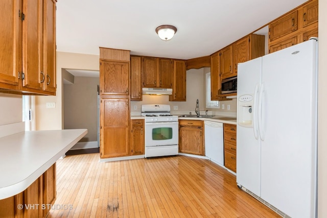 429 W Pierce St, Elburn, IL 60119 - kitchen with white appliances, under cabinet range hood, brown cabinetry, and light countertops