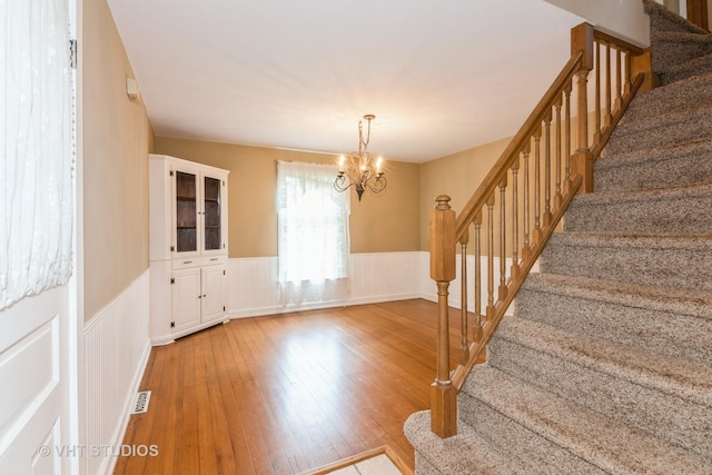 429 W Pierce St, Elburn, IL 60119 - foyer entrance featuring a wainscoted wall, stairway, a chandelier, and hardwood / wood-style flooring