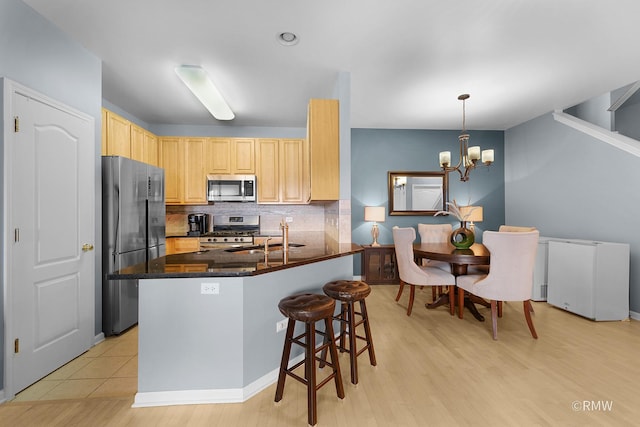 1259 W Lake St Unit 304, Addison, IL 60101 - kitchen with stainless steel appliances, light brown cabinetry, backsplash, a chandelier, and light wood-type flooring