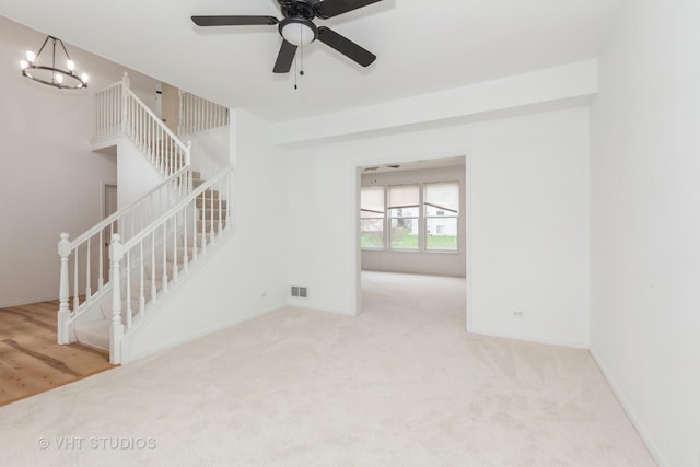 1110 Oakhill Dr, Aurora, IL 60502 - spare room with carpet, stairs, a chandelier, and ceiling fan