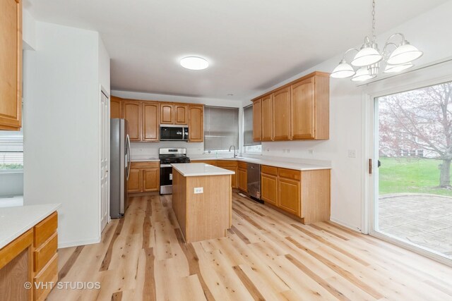 1110 Oakhill Dr, Aurora, IL 60502 - kitchen with stainless steel appliances, a sink, light wood finished floors, a chandelier, and light countertops