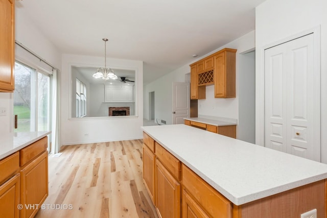1110 Oakhill Dr, Aurora, IL 60502 - kitchen with light wood-type flooring, light countertops, a chandelier, and pendant lighting