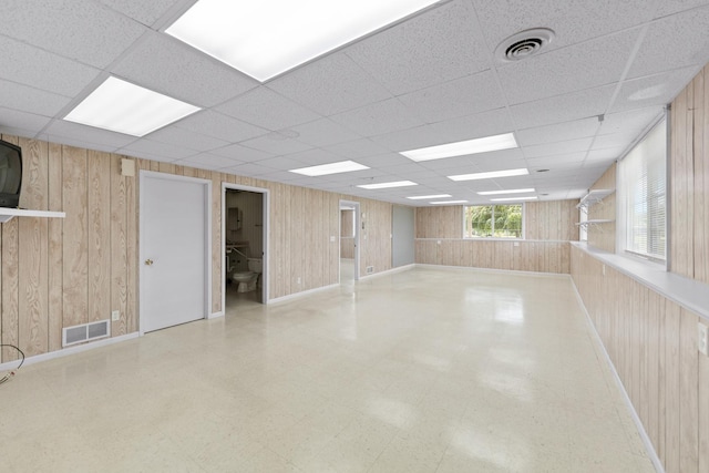 1424 Crimson Ridge Dr, Byron, IL 61010 - spare room with wooden walls, tile patterned floors, and a drop ceiling