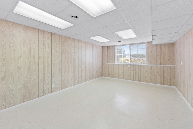 1424 Crimson Ridge Dr, Byron, IL 61010 - empty room featuring wooden walls, a drop ceiling, and tile patterned floors