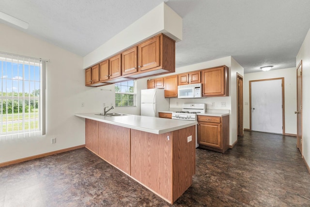 1424 Crimson Ridge Dr, Byron, IL 61010 - kitchen featuring white appliances, a peninsula, brown cabinetry, and lofted ceiling