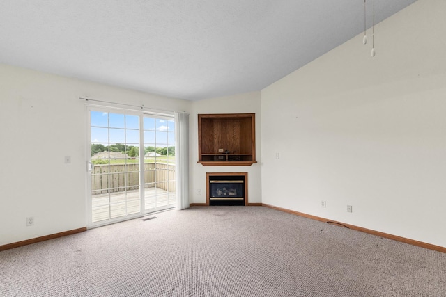1424 Crimson Ridge Dr, Byron, IL 61010 - unfurnished living room with carpet, a glass covered fireplace, and vaulted ceiling