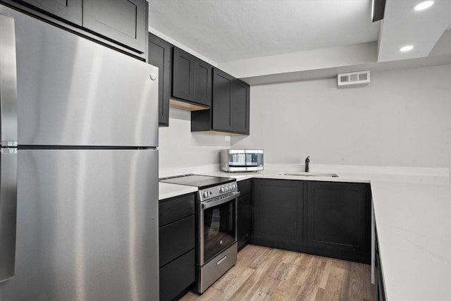 300 N State St Unit 5225, Chicago, IL 60654 - kitchen with stainless steel appliances, light countertops, a sink, recessed lighting, and dark cabinets