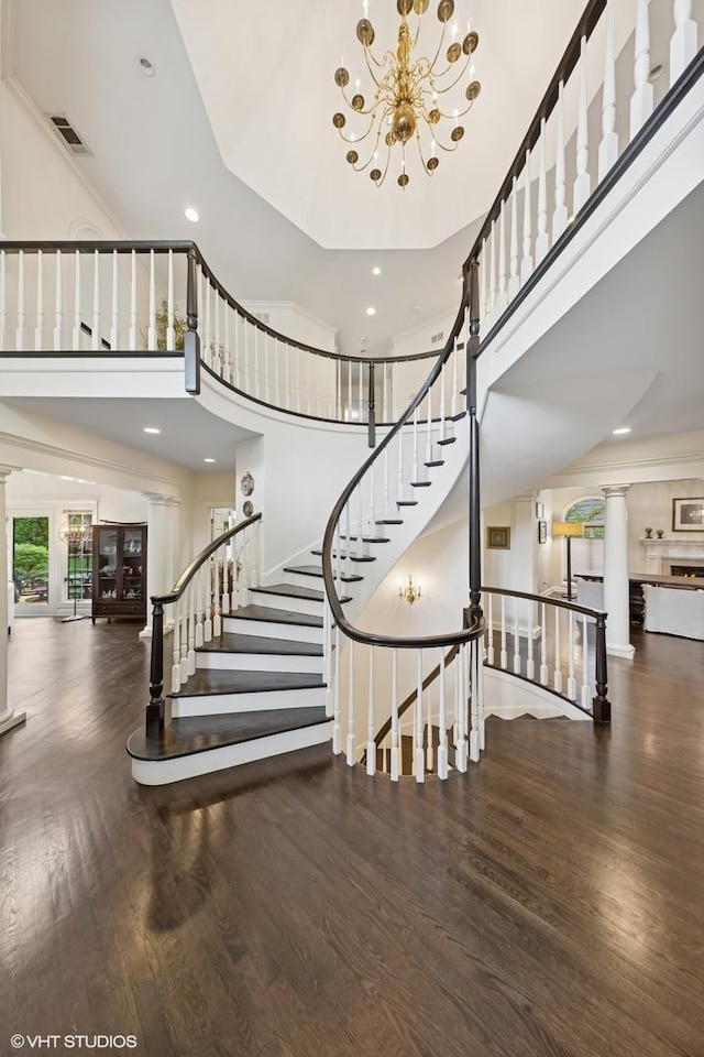 440 Woodside Ave, Hinsdale, IL 60521 - stairs featuring ornate columns, wood finished floors, a towering ceiling, a chandelier, and recessed lighting