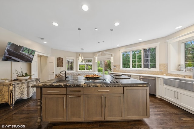 440 Woodside Ave, Hinsdale, IL 60521 - kitchen featuring a sink, stainless steel dishwasher, backsplash, dark stone counters, and a kitchen island
