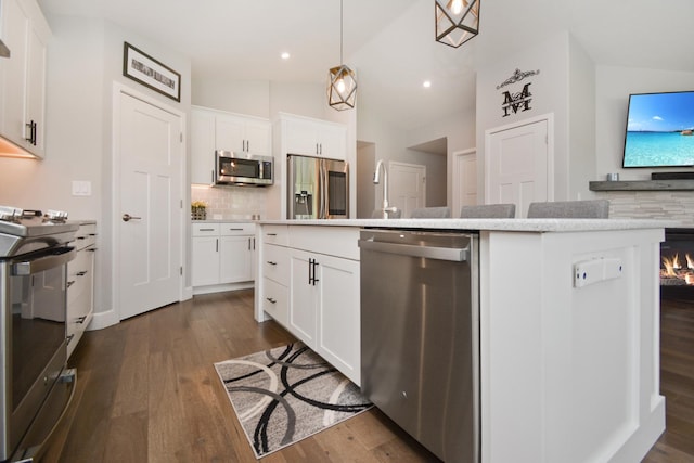 1104 Hershey Rd, Normal, IL 61761 - kitchen with appliances with stainless steel finishes, tasteful backsplash, lofted ceiling, a center island with sink, and dark wood finished floors