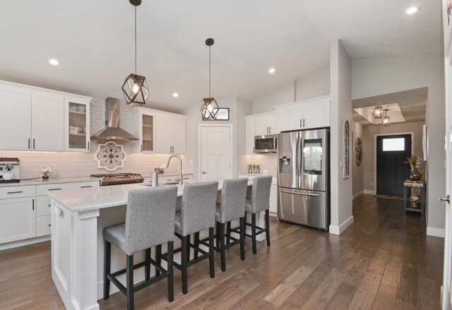 1104 Hershey Rd, Normal, IL 61761 - kitchen featuring stainless steel appliances, wall chimney exhaust hood, backsplash, vaulted ceiling, and white cabinets