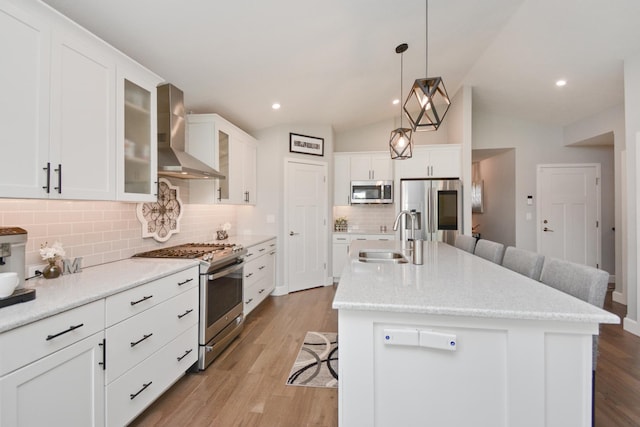 1104 Hershey Rd, Normal, IL 61761 - kitchen featuring wall chimney exhaust hood, appliances with stainless steel finishes, a kitchen bar, backsplash, and an island with sink
