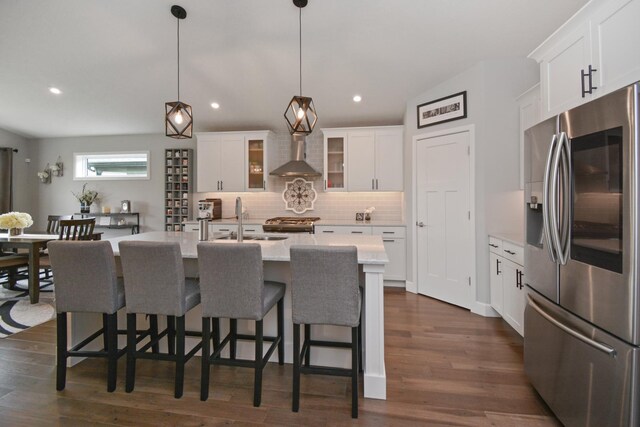 1104 Hershey Rd, Normal, IL 61761 - kitchen featuring appliances with stainless steel finishes, wall chimney range hood, decorative backsplash, a kitchen breakfast bar, and glass insert cabinets