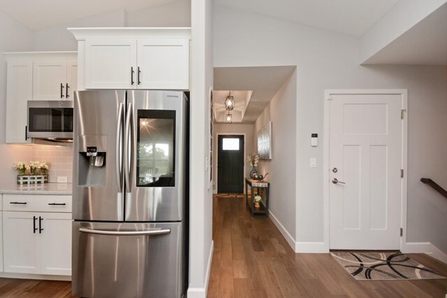 1104 Hershey Rd, Normal, IL 61761 - kitchen featuring stainless steel appliances, lofted ceiling, wood finished floors, decorative backsplash, and white cabinets