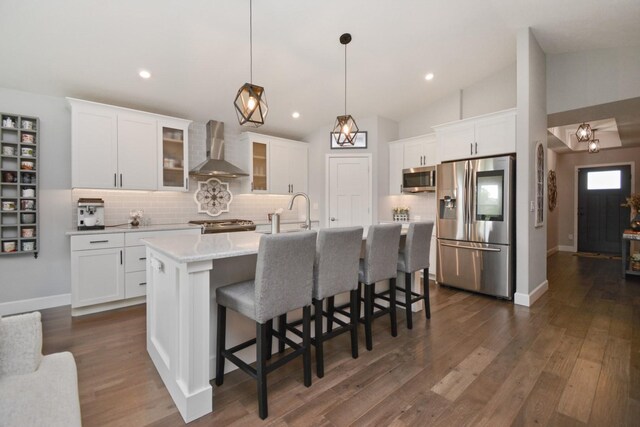 1104 Hershey Rd, Normal, IL 61761 - kitchen featuring stainless steel appliances, wall chimney range hood, backsplash, vaulted ceiling, and white cabinets
